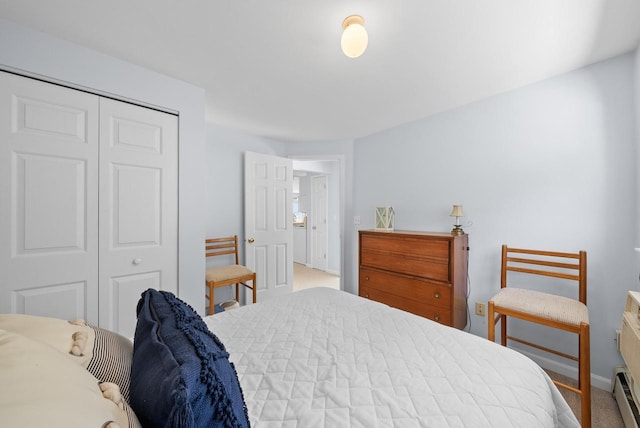 carpeted bedroom with a closet and baseboard heating