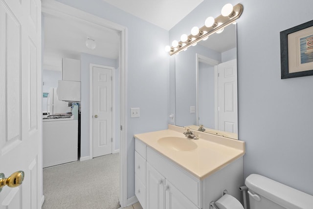 bathroom featuring vanity, washer / clothes dryer, and toilet