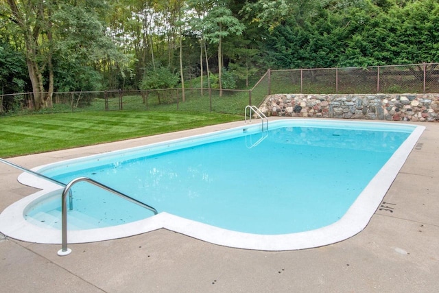 view of pool with a lawn