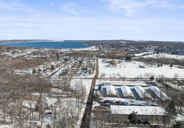 snowy aerial view featuring a water view