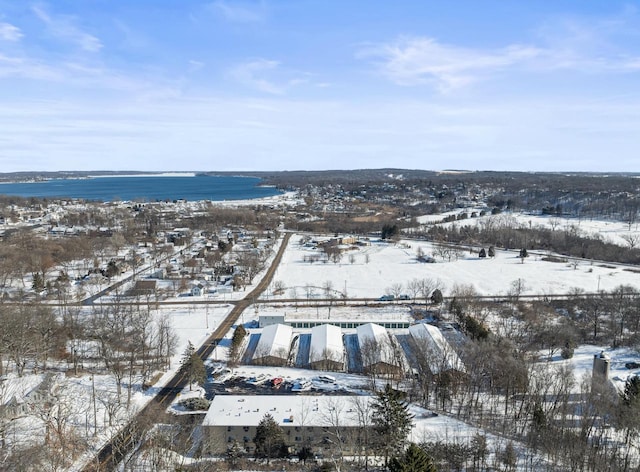 snowy aerial view featuring a water view