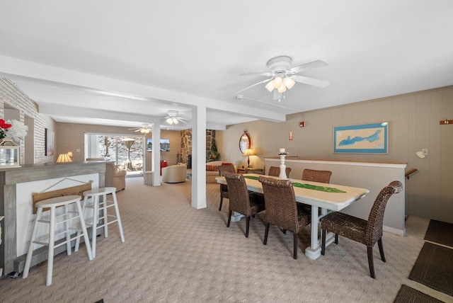 carpeted dining area with beam ceiling and ceiling fan