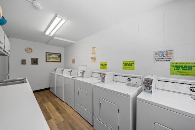 washroom with dark hardwood / wood-style floors, washer and clothes dryer, and sink