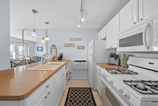 kitchen featuring sink, white appliances, a wall unit AC, white cabinets, and light tile patterned flooring