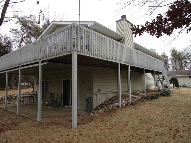 rear view of house featuring a deck and a patio area