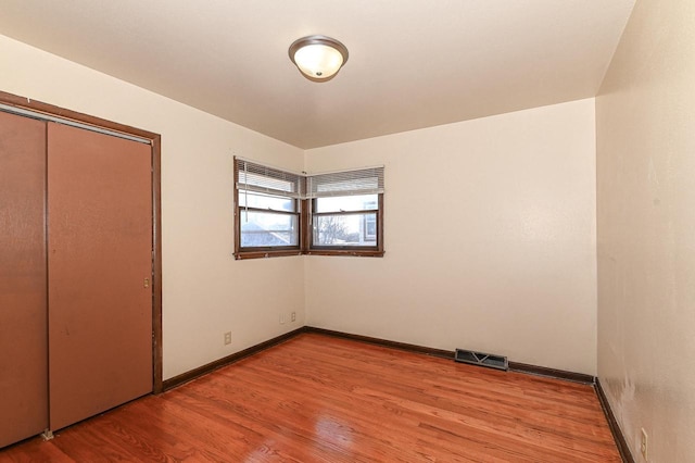 unfurnished bedroom featuring light hardwood / wood-style floors and a closet