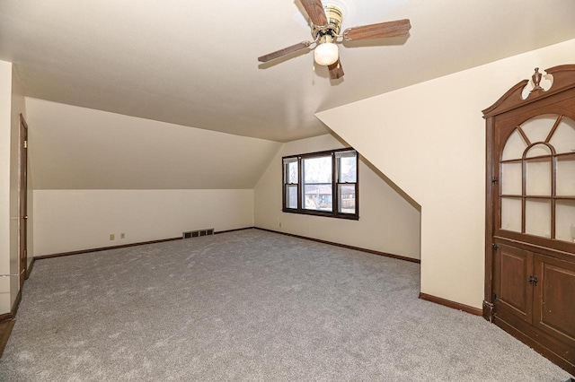 additional living space with light carpet, vaulted ceiling, and ceiling fan