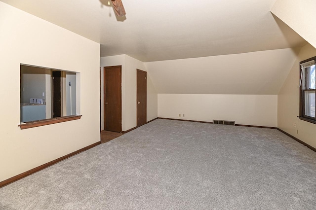 additional living space with lofted ceiling, carpet flooring, and ceiling fan