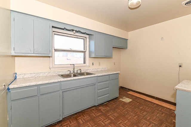 kitchen featuring dark parquet flooring, gray cabinets, and sink