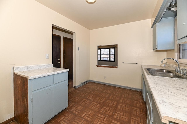 kitchen with dark parquet flooring, sink, and gray cabinetry