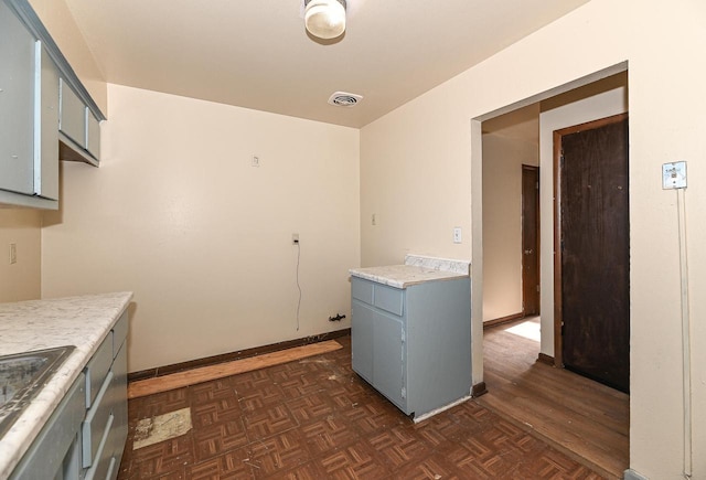 laundry room featuring dark parquet flooring and sink