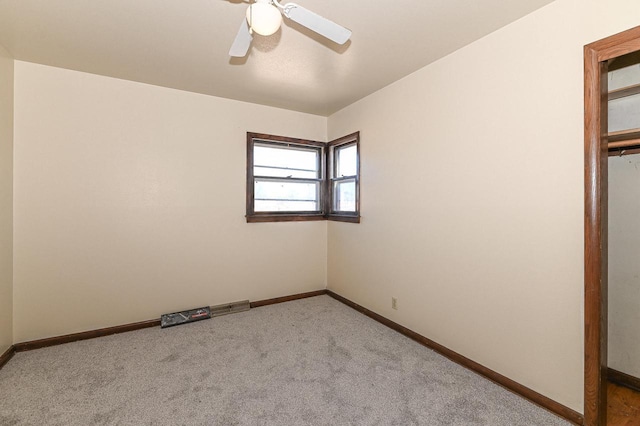 unfurnished bedroom featuring light carpet, a closet, and ceiling fan