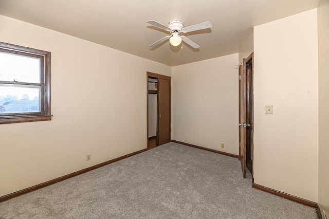 unfurnished bedroom featuring ceiling fan, light colored carpet, and a closet