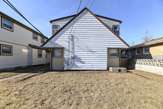 rear view of property with a yard and central AC unit