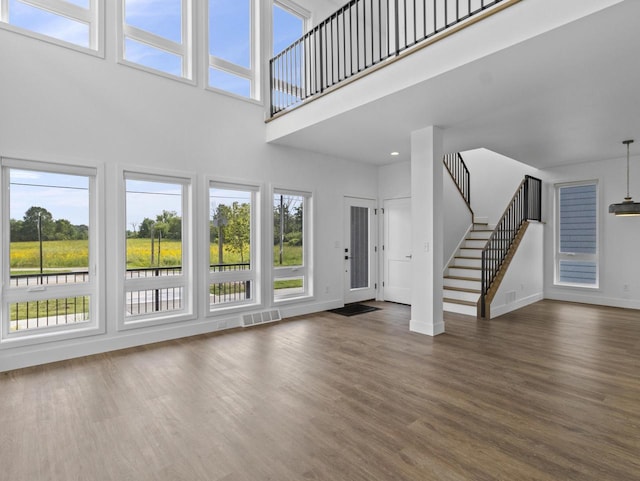 unfurnished living room featuring dark hardwood / wood-style floors and a high ceiling