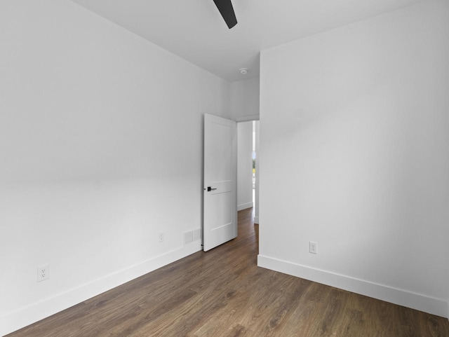 spare room with dark hardwood / wood-style floors and ceiling fan