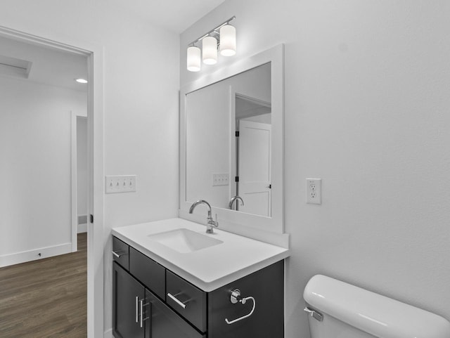 bathroom featuring vanity, hardwood / wood-style flooring, and toilet