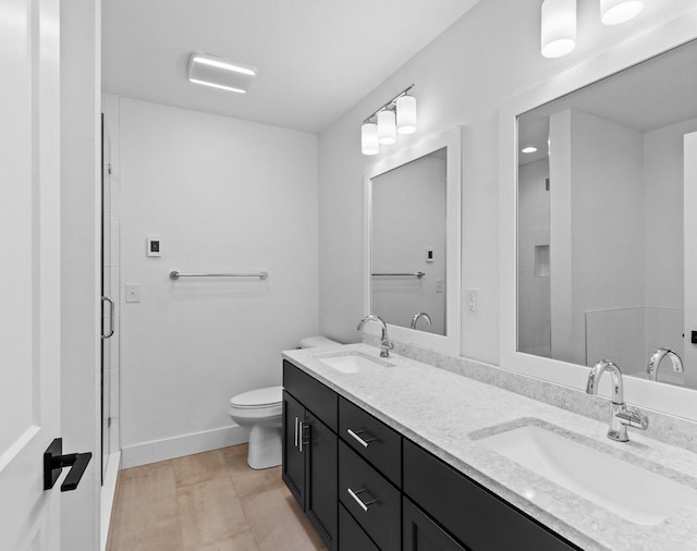 bathroom featuring vanity, toilet, and a shower with door