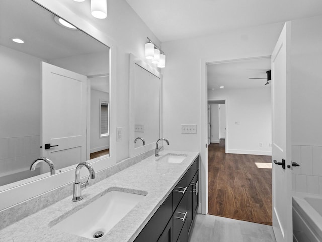 bathroom with hardwood / wood-style flooring, vanity, and a bathtub