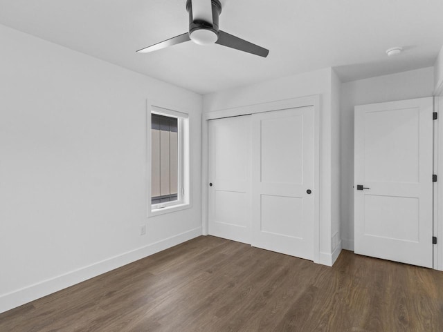 unfurnished bedroom featuring dark hardwood / wood-style floors, ceiling fan, and a closet