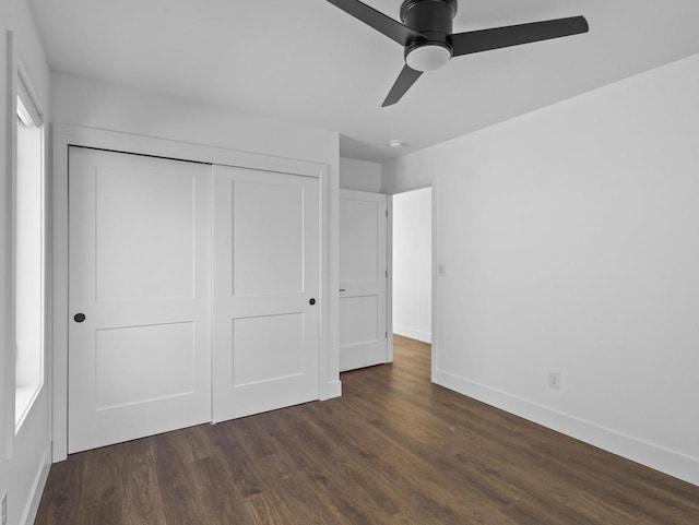 unfurnished bedroom featuring dark wood-type flooring, ceiling fan, and a closet