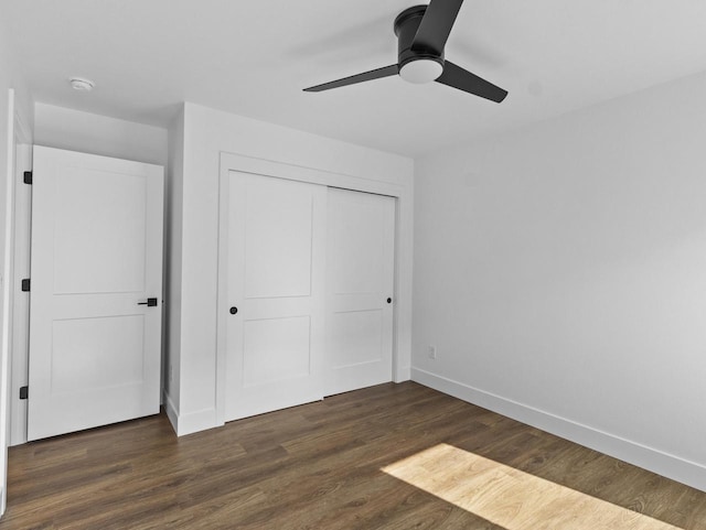 unfurnished bedroom featuring ceiling fan, dark hardwood / wood-style flooring, and a closet