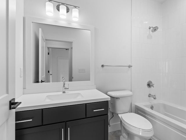 full bathroom featuring tiled shower / bath, vanity, and toilet