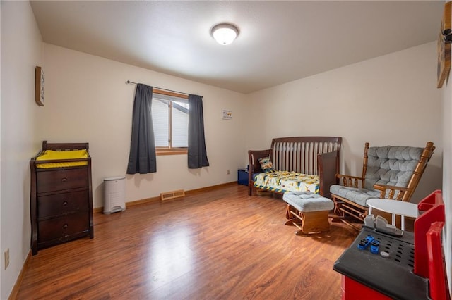 bedroom featuring a nursery area and hardwood / wood-style flooring