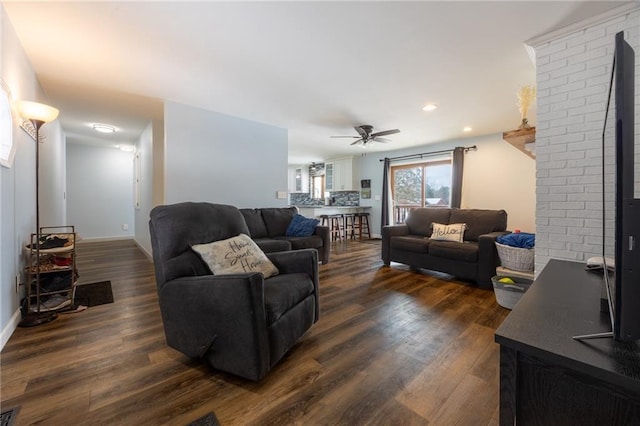 living room featuring ceiling fan and dark hardwood / wood-style floors