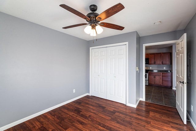 unfurnished bedroom featuring dark wood-type flooring, ceiling fan, and a closet