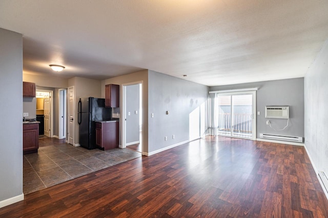 unfurnished living room with baseboard heating, dark hardwood / wood-style floors, and a wall unit AC