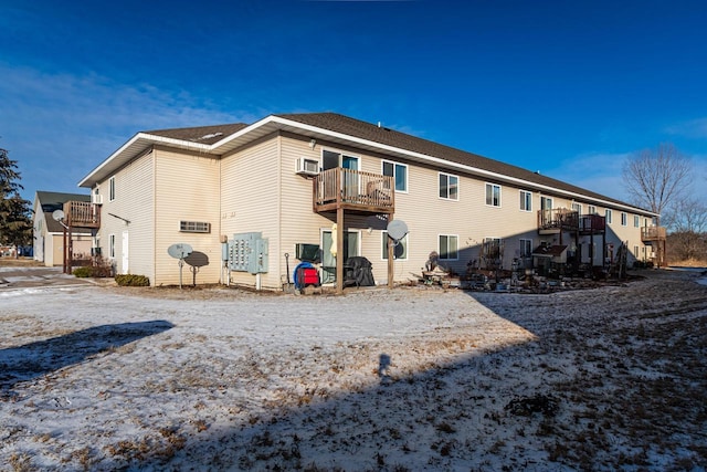 rear view of property featuring a wall mounted AC and a balcony