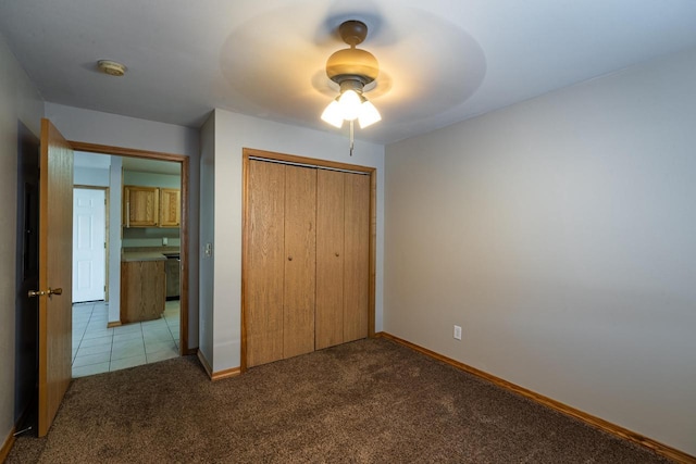 unfurnished bedroom with light colored carpet, a closet, and ceiling fan