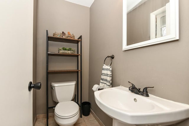 bathroom featuring toilet, tile patterned flooring, and sink