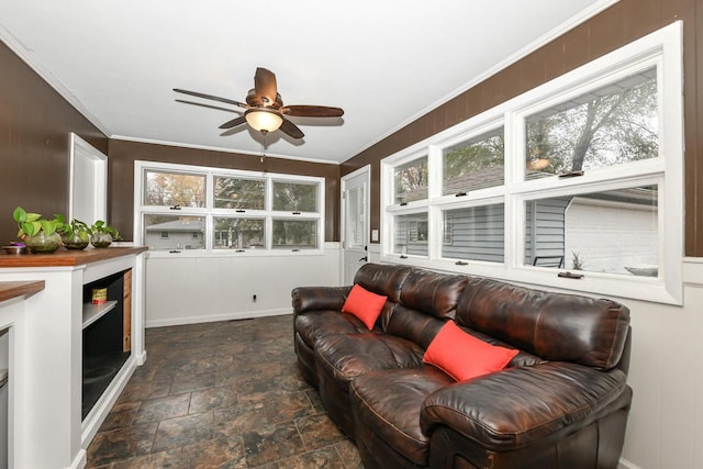 living room with ornamental molding and ceiling fan