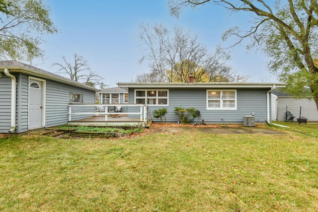 rear view of property featuring a lawn, central air condition unit, and a deck