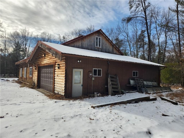 view of snowy exterior with a garage