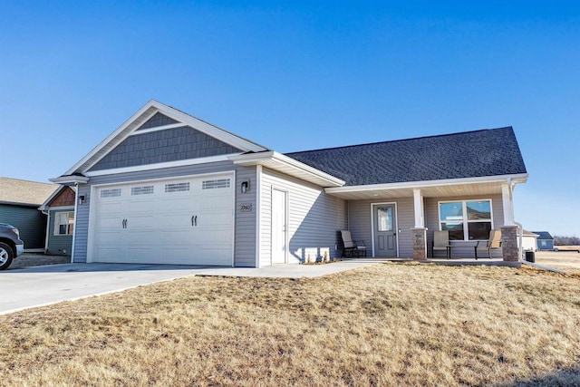 view of front of property featuring a garage, a front yard, and covered porch