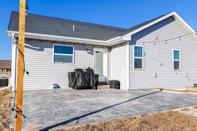 rear view of property with central AC unit and a patio area