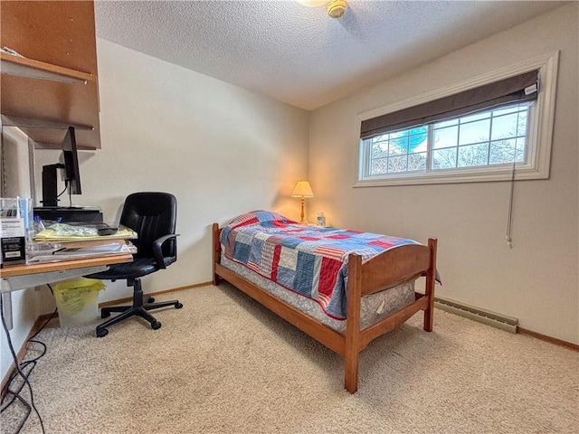 carpeted bedroom featuring a baseboard radiator and a textured ceiling