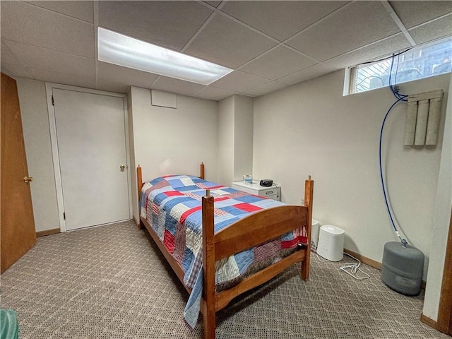 bedroom featuring carpet and a drop ceiling