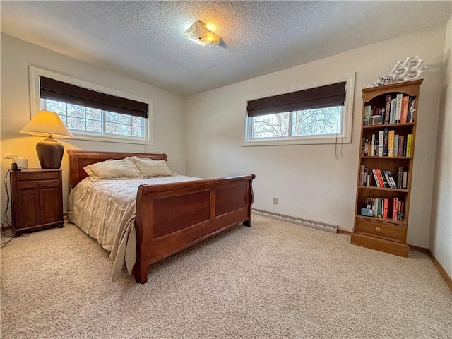 carpeted bedroom with a baseboard radiator and a textured ceiling