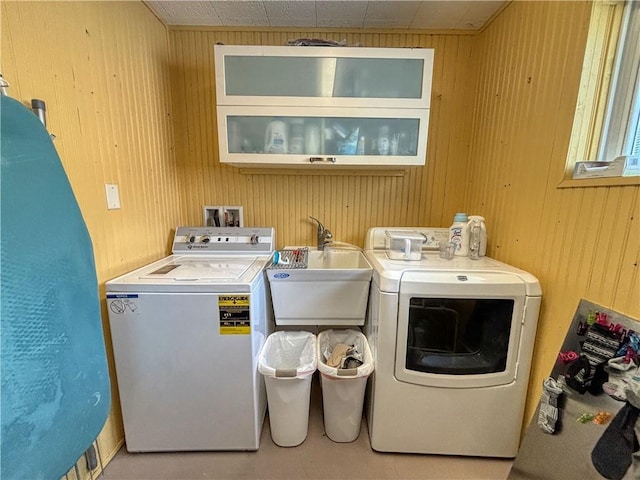 laundry room featuring sink, washer and clothes dryer, and wooden walls