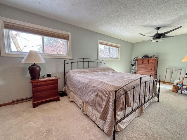 carpeted bedroom featuring a textured ceiling and ceiling fan