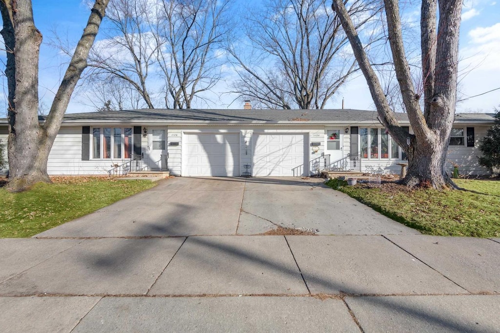 ranch-style house with a garage and a front yard