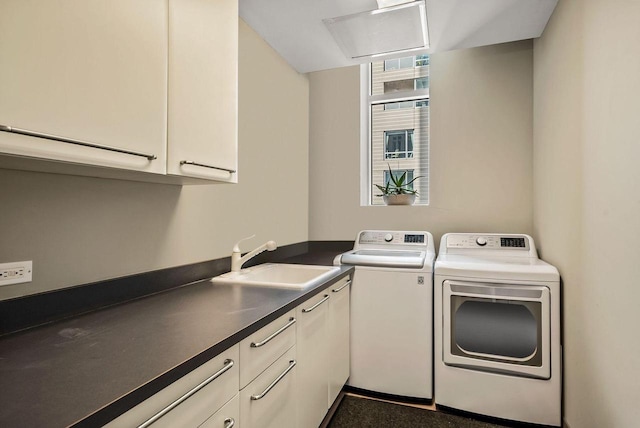 laundry area featuring cabinets, separate washer and dryer, and sink