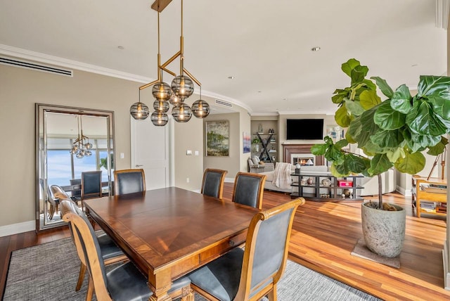 dining room with hardwood / wood-style flooring and crown molding