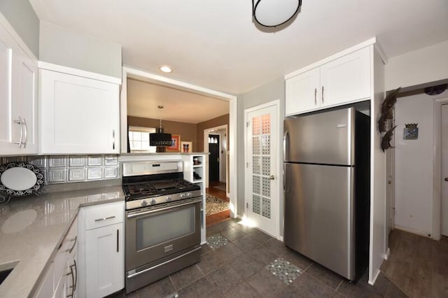 kitchen featuring white cabinetry, decorative light fixtures, tasteful backsplash, and appliances with stainless steel finishes