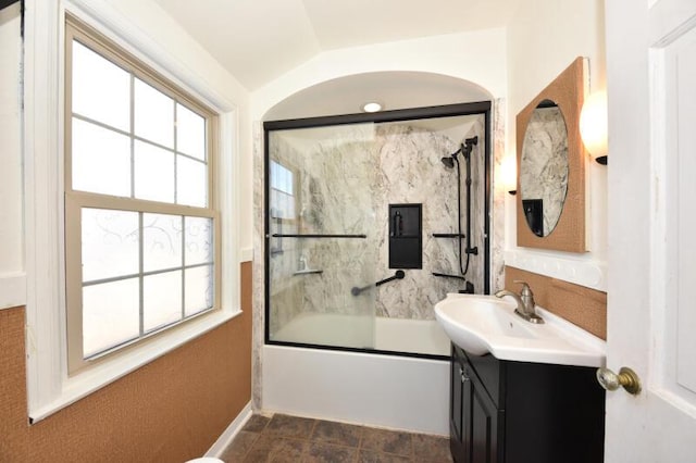 bathroom with vanity, combined bath / shower with glass door, a wealth of natural light, and lofted ceiling