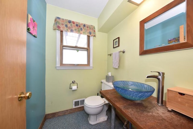 bathroom featuring toilet, tile patterned flooring, and sink